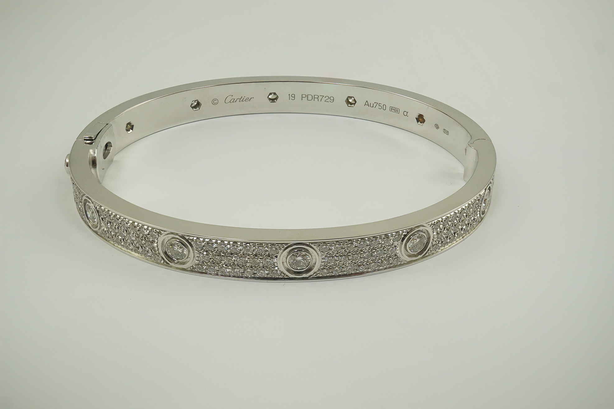 A modern Cartier 18k white gold and diamond cluster set hinged 'Love' bangle